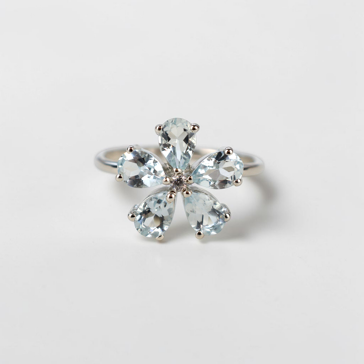 Bellisのスカイブルートパーズを使用したフラワーカットのシルバー925リング。ジルコンが輝く花びらデザイン